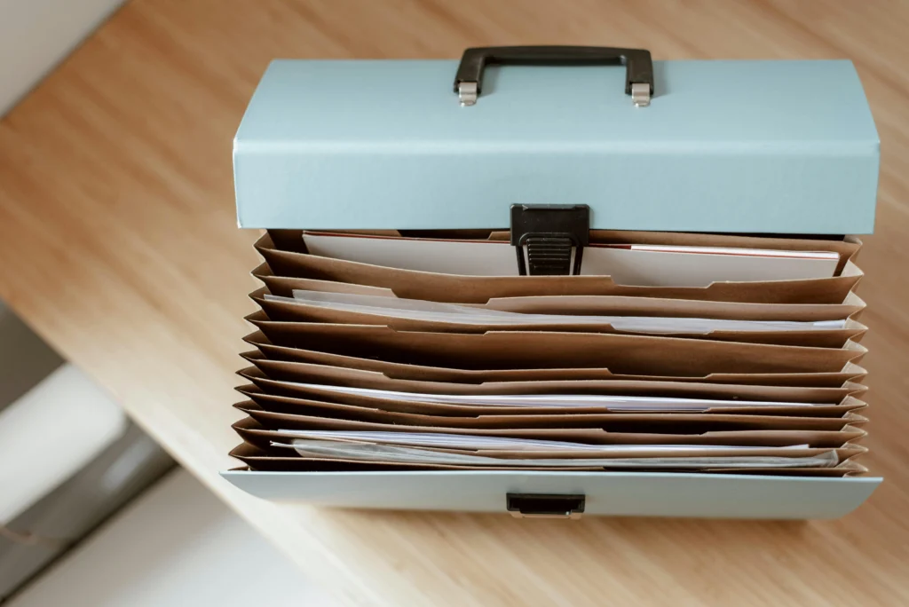 un attaché case bleu ouvert avec plusieurs dossier poser sur une table