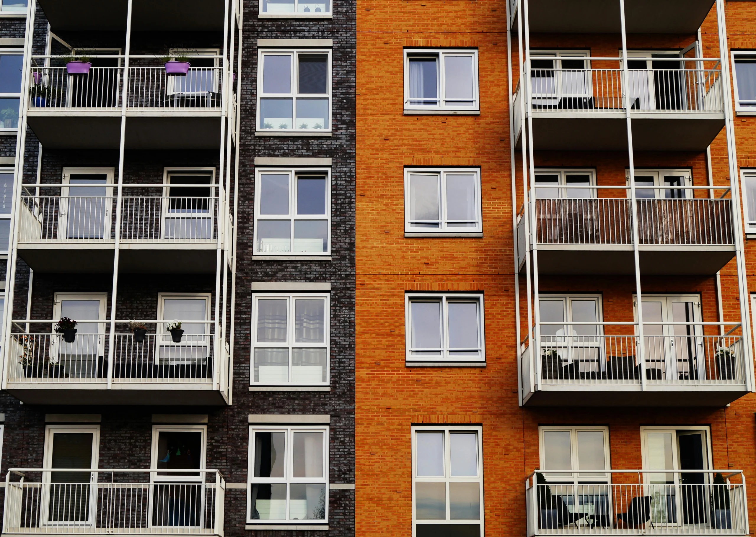 façade d'immeuble orange et noir balcons blancs